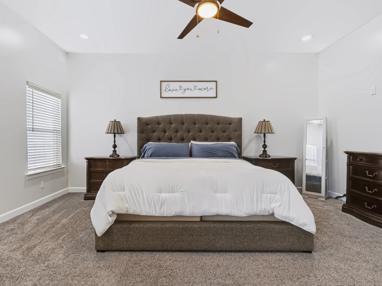 Primary bedroom with upholstered bed and matching bedside lamps
